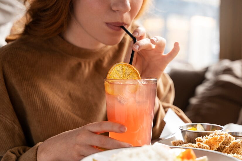 seorang wanita sedang meminum minuman berasa